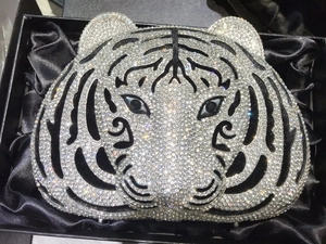 Close-up of silver tiger head evening clutch bag with sparkling rhinestones in a gift box