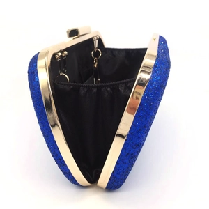 Detailed interior of blue sequin evening clutch with gold metal frame and black lining