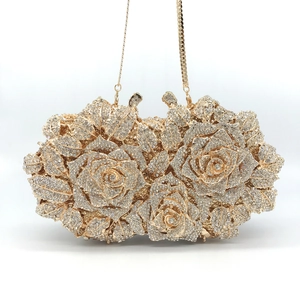 Macro detail of luxury evening bag with 3D rose clusters and sparkling crystals