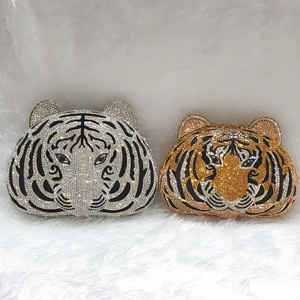 Detailed view of silver and gold tiger head clutch bags with hand-set rhinestones
