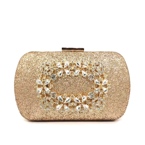 Macro shot of gold sequin evening clutch featuring a floral crystal rhinestone clasp