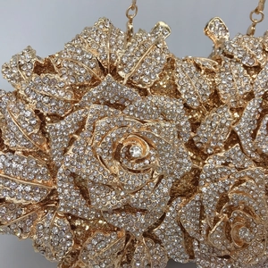 Close-up of golden rose evening clutch featuring intricate flower petals and crystal details