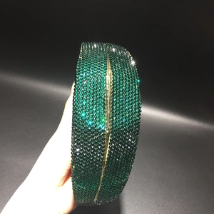 Detail of dark green crystal evening clutch bag with gold metal frame and hand-set rhinestones