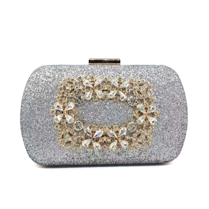 Detailed view of silver sequin evening clutch with crystal buckle and gold clasp