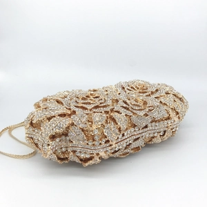 Detailed view of hollow rose pattern and sparkling diamonds on gold evening clutch