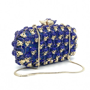 Détails des strass bleu foncé et des crânes dorés sur cette pochette de soirée luxe