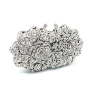 Close-up of a silver evening clutch featuring intricate rose-shaped crystal embellishments