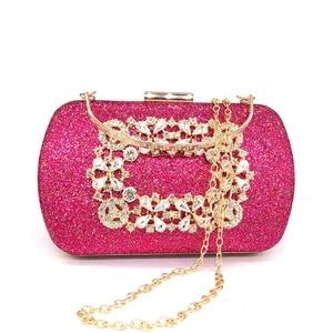 Close-up of sparkling rose red sequined evening clutch with diamond buckle and gold handle