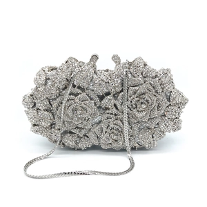 Macro shot of silver hollow rose clutch with sparkling diamonds and metal chain strap