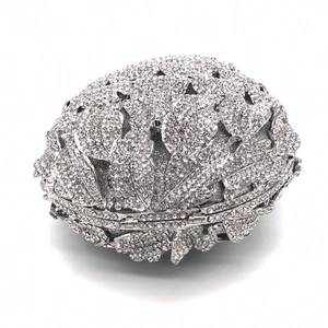 Detail of silver hollow metal evening clutch featuring pineapple pattern and sparkling crystals