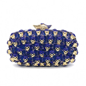 Détails de strass bleus et de têtes de mort dorées sur cette pochette de soirée de luxe