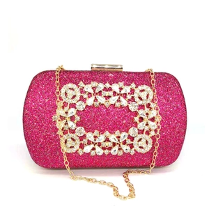 Macro detail of fuchsia glitter surface and crystal square buckle on evening clutch
