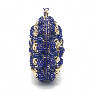 Vue détaillée de la pochette de soirée bleue à strass avec détails crâne dorés