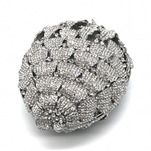 Close-up of luxury hollow metal evening clutch with silver rhinestones and flower texture