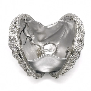 Detailed top view of open heart-shaped silver evening clutch with rhinestones and chain