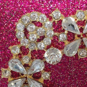 Macro detail of luxury crystal diamond buckle with intricate stone setting on gold base