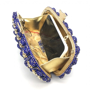 Pochette de soirée dorée ajourée avec strass bleus et bandoulière chaîne métal
