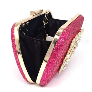 Detail of fuchsia evening clutch showing interior lining, gold frame, and crystal accents