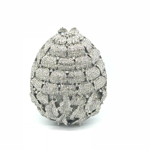 Detailed view of silver hollowed-out evening bag with intricate rhinestone floral patterns