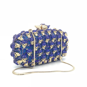 Détail de la pochette en cristal bleu roi avec crânes dorés et fermoir en aigle
