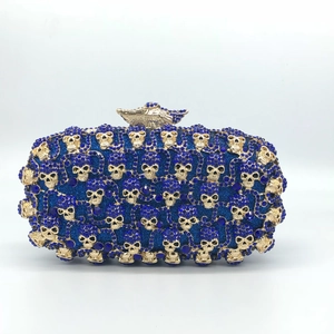 Détail d'ornements tête de mort dorés et strass bleus sur cette pochette de luxe