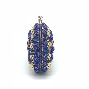 Détail d'une pochette de luxe en cristaux bleu roi avec ornements dorés ajourés