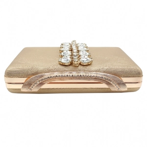 Macro shot of gold evening clutch featuring rhinestone embellishments and a metal frame