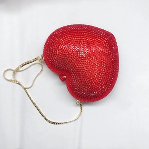 Detail der roten herzförmigen Clutch mit funkelnden Kristallen und goldener Kette