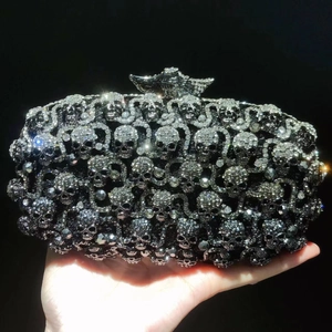 Détail de pochette de soirée noire luxueuse avec crânes étincelants et décor en cristaux