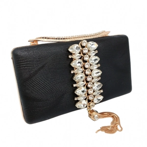 Close-up of black evening bag with pear-shaped rhinestones and gold chain tassels