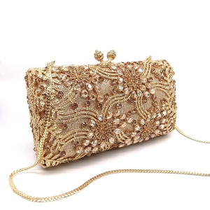 Macro detail of luxury gold evening clutch with crystal flower pattern and metal clasp