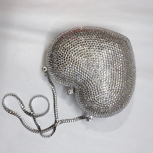 Detailansicht der herzförmigen Abendtasche mit dichten silbernen Strasssteinen und Kette