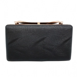 Macro detail of wave texture on black evening clutch with rose gold metal clasp