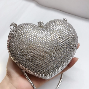 Detailansicht der silbernen Herz-Clutch mit glitzernden Strasssteinen und Metallkette