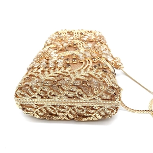 Detail of golden hollow-out evening clutch with coffee and clear crystal rhinestones