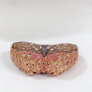 Macro shot of butterfly evening clutch with pink and purple rhinestones on gold frame