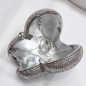 Detail der Innenseite einer herzförmigen silbernen Strass-Clutch mit silbernem Lederfutter