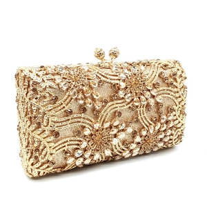 Macro detail of luxury gold evening clutch with sparkling floral rhinestone patterns