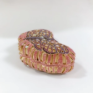 Detail of heart-shaped evening clutch with pink and purple butterfly rhinestone patterns
