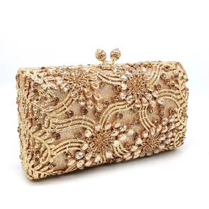 Close-up of golden evening clutch with intricate floral rhinestones and beaded patterns