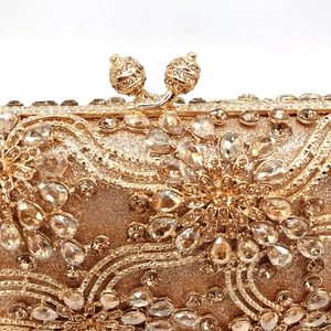 Detail of gold evening clutch featuring intricate floral rhinestone patterns and metal closure