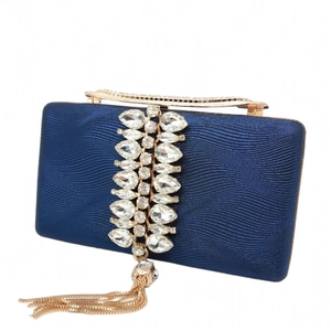 Detail of dark blue ripples evening bag with crystal embellishments and gold tassel