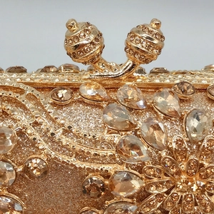 Macro shot of champagne gold evening clutch with hollow rhinestones and metal closure
