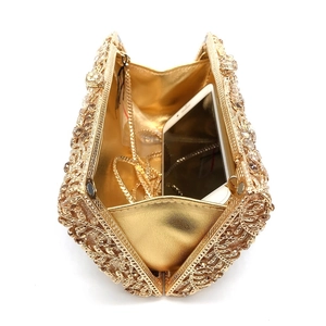 Detail view of gold rhinestone evening bag interior showing storage space for a smartphone