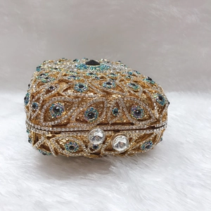 Nahaufnahme der goldenen Abendtasche mit Kristall-Evil-Eye-Muster und Juwelenverschluss