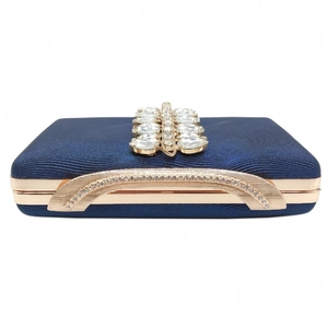 Close-up of navy evening clutch featuring a gold handle and double row of sparkling rhinestones