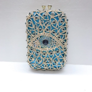 Makroaufnahme der Evil Eye Abendtasche mit blauem Glitzergrund und goldenen Metalllinien