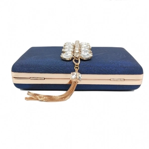 Detail of dark blue evening clutch with rose gold frame and crystal tassel decoration