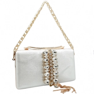 Detail of silver wavy clutch with crystal accents, gold chain, and metal tassel