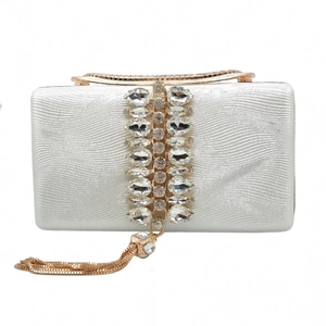 Close-up of sparkling evening clutch with rose gold chain tassels and crystal rhinestones